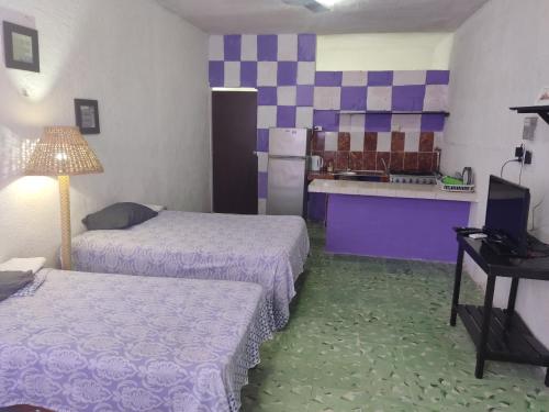 um quarto de hotel com duas camas e uma cozinha em Hostal Maruvillas em Mérida