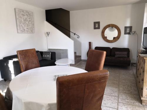 salon z białym stołem i krzesłami w obiekcie LA BASTIDE DES MACALO w mieście Pont-Saint-Esprit