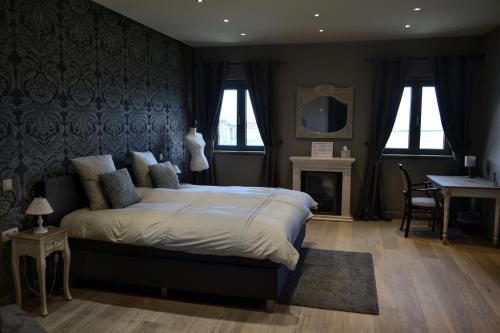 a bedroom with a large bed and a fireplace at Hoeve Lavigne in Wellen