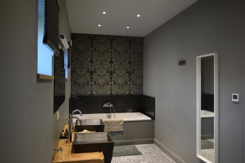 een badkamer met een wastafel en een bad bij Hoeve Lavigne in Wellen