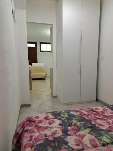 a room with a bed with pink flowers on it at Domus de mare in Cala Gonone
