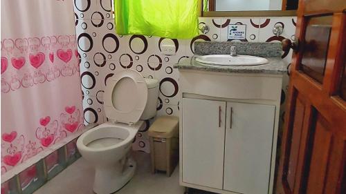 Baño pequeño con aseo y lavamanos en Hostal La Siesta, en Baños
