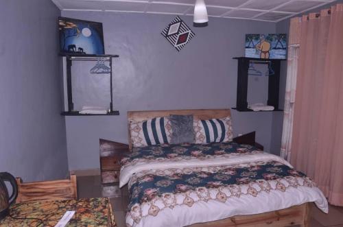 a bedroom with a bed and two shelves on the wall at Tommy's Budget Rooms in Kigali