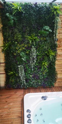 a green wall with plants and a sink at 2 chambres à 15 mn de la mer en pleine nature Jacuzzi dispo du 01 avril au 15 octobre in Anneville-sur-Scie