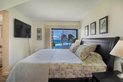 a bedroom with a bed with a view of the ocean at Sealodge Villa H5 in Princeville