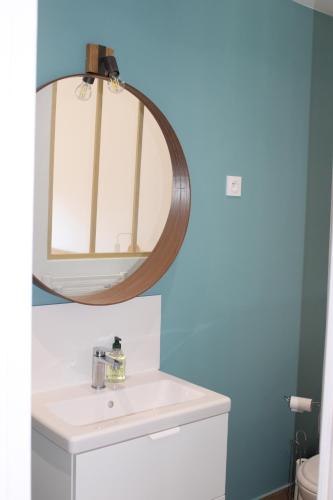 ein Badezimmer mit Waschbecken und Spiegel in der Unterkunft Maison 8 personnes à 100 m de la plage de la Clère in Le Grand Vieil