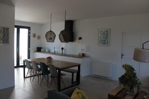 une cuisine et une salle à manger avec une table et des chaises dans l'établissement Maison 8 personnes à 100 m de la plage de la Clère, à Le Grand Vieil