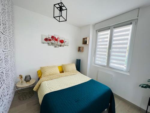 een slaapkamer met een bed en een raam bij Maisonnette indépendante au calme in Vittel