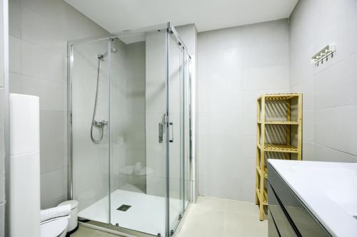 een badkamer met een glazen douche en een toilet bij Charming Madrid La Elipa - 3 dormitorios in Madrid