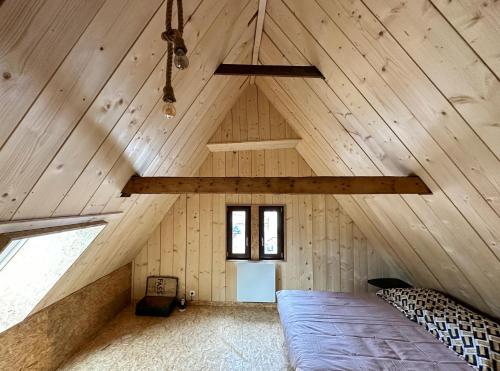 a room with a bed in a wooden attic at Escale au cœur de l'Alsace in Wolfisheim