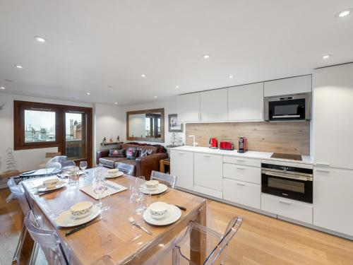 une cuisine et un salon avec une table et des chaises dans l'établissement Appartement rénové avec balcon - Centre de Courchevel 1850, proche remontées mécaniques - FR-1-564-87, à Courchevel