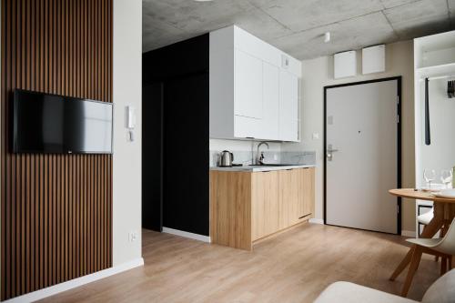 a kitchen with white cabinets and a sink and a table at THE HOUSE near Lake & Old Town in Olsztyn