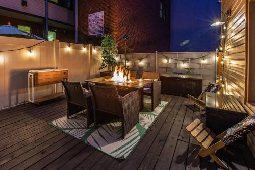 a wooden deck with a table and chairs and a fireplace at King Bed / Free Parking / BBQ / Fire pit / Arcade in Pittsburgh