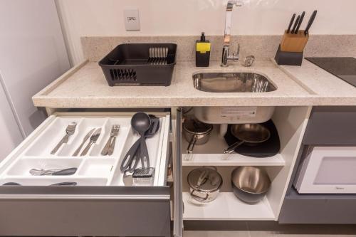 a kitchen counter with a sink and utensils at LIV - Apartamento 904 in Porto Alegre