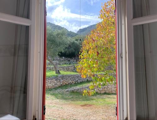 otwartym oknem z widokiem na kamienną ścianę w obiekcie Pandora Villa w mieście Vathi