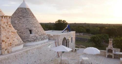 a statue sitting on top of a building with an umbrella at TRULLI ALLEGRETTI in Noci