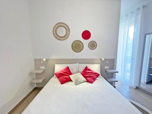 a white bed with red pillows in a room at Affittacamere Casa Lilibet in San Benedetto del Tronto
