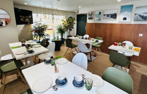 a restaurant with white tables and chairs at Residhome Quai d’Ivry in Ivry-sur-Seine