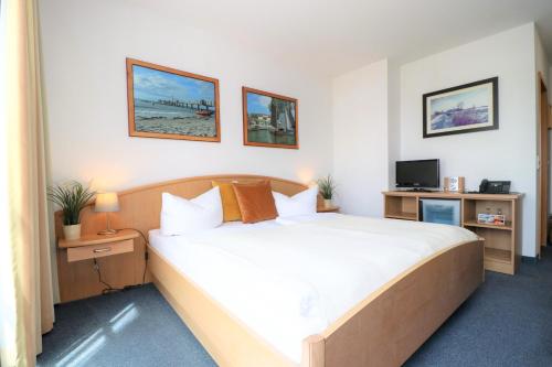 um quarto de hotel com uma cama e uma televisão em Ferienzimmeranlage Deutsches Haus Deutsches Haus App 18 em Wustrow