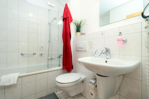 uma casa de banho com um WC, um lavatório e uma banheira em Ferienzimmeranlage Deutsches Haus Deutsches Haus App 18 em Wustrow