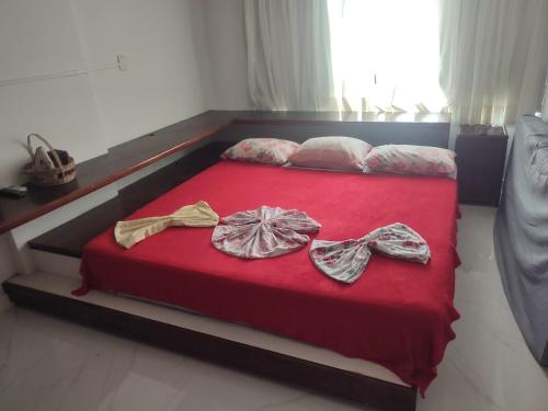 a bed with two bows on top of it at Apartamento Farol Barra Flat in Salvador