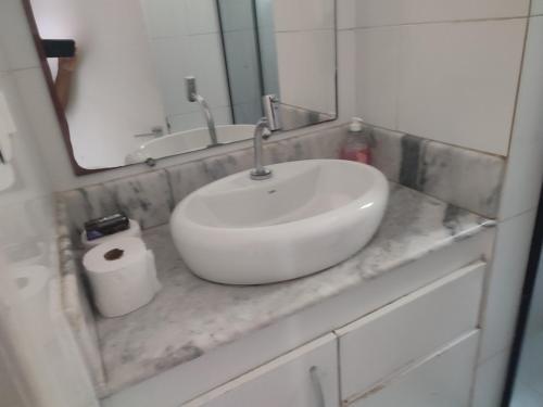 baño con lavabo y papel higiénico en Apartamento Farol Barra Flat, en Salvador