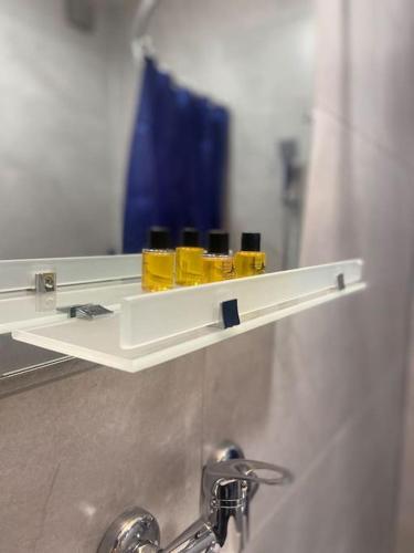 a shelf with three bottles on it in front of a mirror at Luca's Apartment in old tbilisi in Tbilisi City