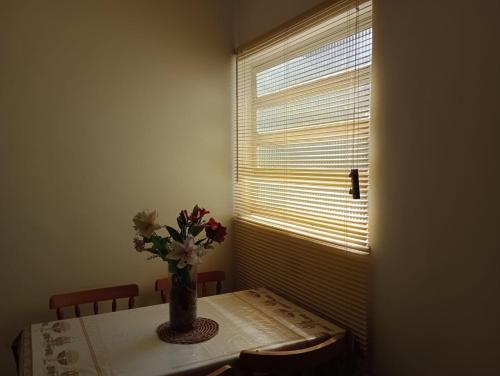 a dining room table with a vase of flowers on it at Apartamento aconchegante com estacionamento na 25 de março in Sao Paulo