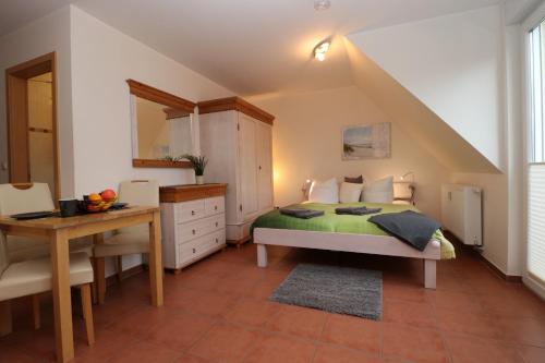um quarto com uma cama, uma mesa e uma secretária em "Strandkoje" Strandkoje, App 07 em Neuhaus