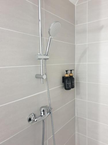 a shower with a shower head in a bathroom at Le Safari - Dormir Comme A La Maison in Guérande