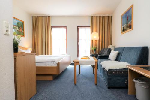 a hotel room with a bed and a couch at Ferienzimmeranlage Deutsches Haus Deutsches Haus App 20 in Wustrow