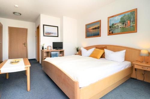 a hotel room with a bed and a desk at Ferienzimmeranlage Deutsches Haus Deutsches Haus App 20 in Wustrow