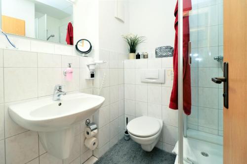 ein weißes Bad mit einem Waschbecken und einem WC in der Unterkunft Ferienzimmeranlage Deutsches Haus Deutsches Haus App 25 in Wustrow