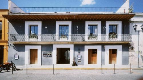 ein Schwarz-Weiß-Gebäude mit einem Balkon in der Unterkunft Hotel Sin Nombre in Oaxaca de Juárez