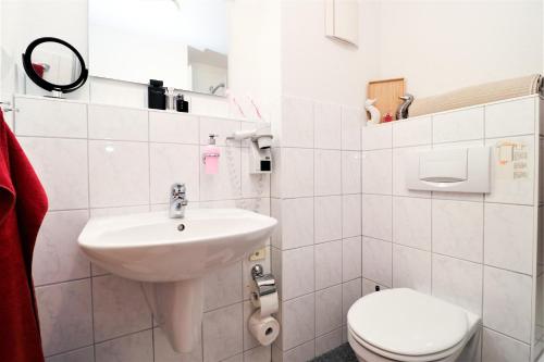 een witte badkamer met een wastafel en een toilet bij Ferienzimmeranlage Deutsches Haus Deutsches Haus App 31 in Wustrow