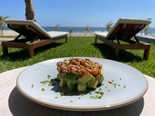 un plato de comida en una mesa cerca de la playa en Casa Aloha Punta Sal en La Bocana