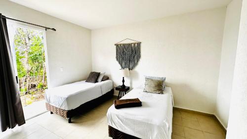 sypialnia z dwoma łóżkami i oknem w obiekcie Franks House "Shared House" with Pool w mieście Cancún