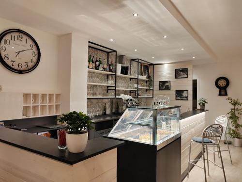 un restaurant avec une horloge et un comptoir avec un aquarium dans l'établissement Hotel Luisa, à Brenzone