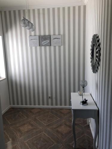 a room with a table and a striped wall at Apartamento Rio Minho in Vila Nova de Cerveira