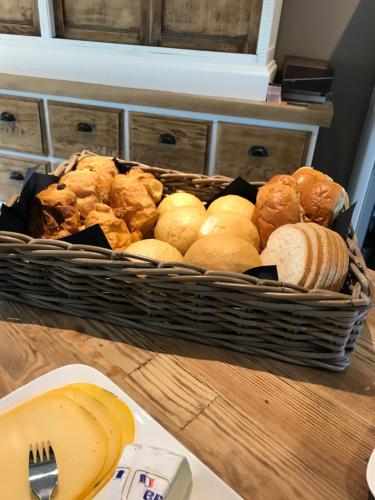 a basket of bread and pastries on a table at Hoeve Lavigne in Wellen