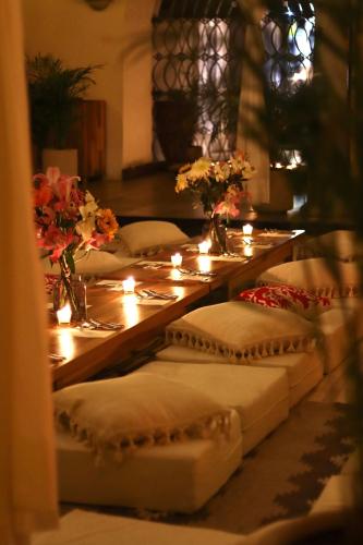 a long table with several pillows and candles on it at Hotel Sin Nombre in Oaxaca City