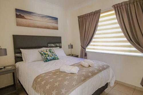 a bedroom with a bed with two towels on it at The Lemon Tree Oasis - Solar in Centurion