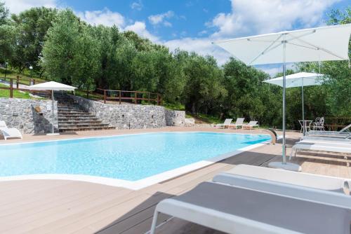 uma piscina com um pátio e um guarda-sol em Tenuta Terre di Bosco em San Giovanni a Piro