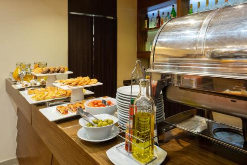 a buffet with plates of food and a bottle of wine at Urban Suites Recoleta Boutique Hotel in Buenos Aires