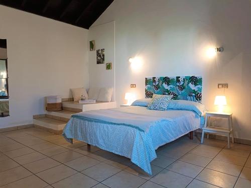 a bedroom with a bed with a blue comforter at Iam Villaverde in La Oliva