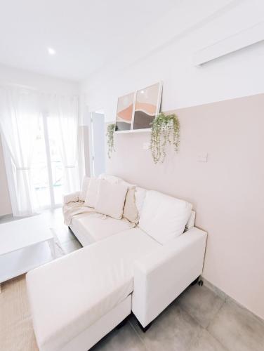a white living room with a white couch at Shelter next to the beach in Larnaca