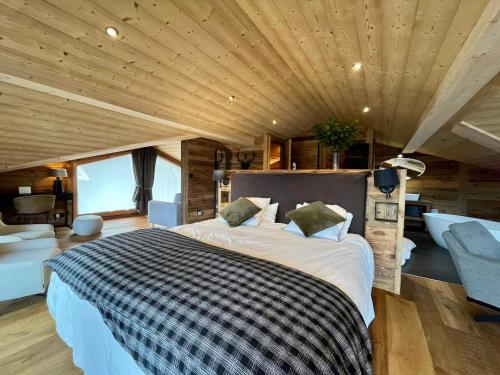 un grande letto in una camera con soffitto in legno di Chalet Les Gets, 5 pièces, 14 personnes - FR-1-598-41 a Les Gets