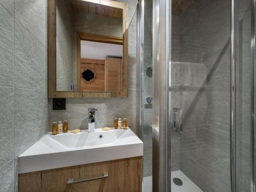 une salle de bain avec un lavabo blanc et une douche dans l'établissement Appartement T4 à Courchevel, proche des pistes, avec terrasse, parking, et services inclus - FR-1-563-13, à Courchevel