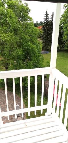 a white porch railing with a view of a yard at Country Residence near Vienna in Stillfried