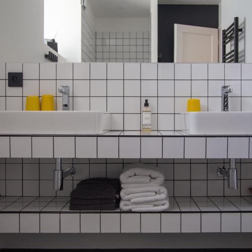 La salle de bains est pourvue d'un lavabo et de serviettes sur une étagère. dans l'établissement Maison Cimes, aux Orres